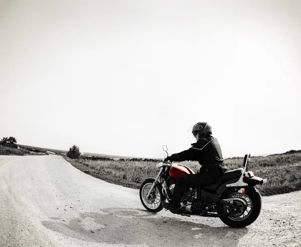 Motociclista na estrada contra o céu — Fotografia de Stock