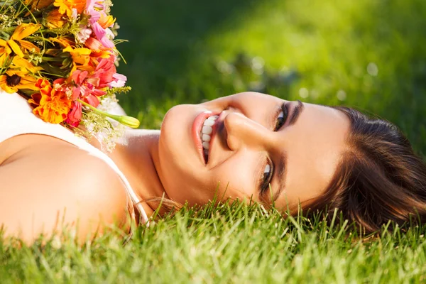 Beautiful young girl relaxing on green grass — Stock Photo, Image