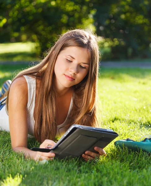 Szczęśliwa młoda dziewczyna przy użyciu komputera typu tablet — Zdjęcie stockowe
