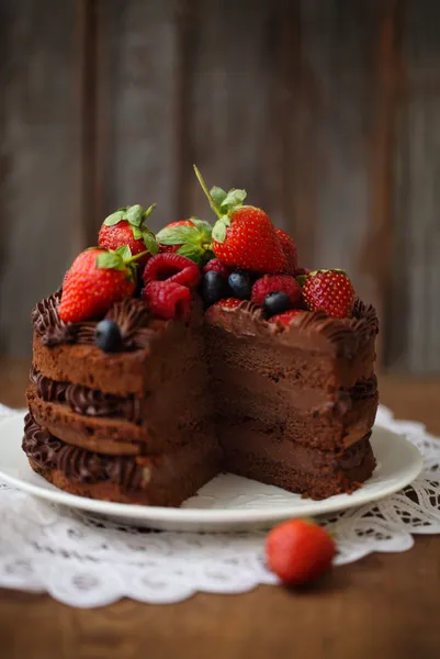 Pedaço de bolo de chocolate com cereja e bagas frescas — Fotografia de Stock