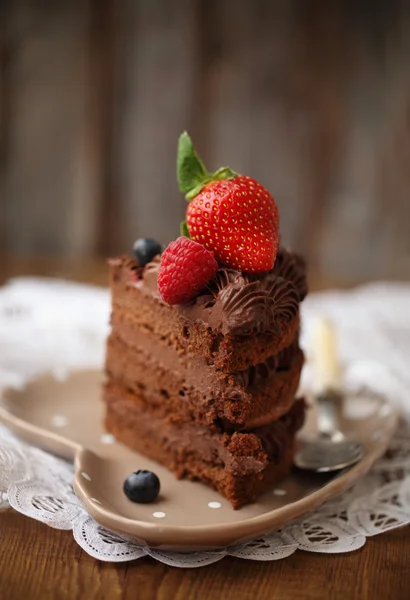 Pedaço de bolo de chocolate com cereja e bagas frescas — Fotografia de Stock