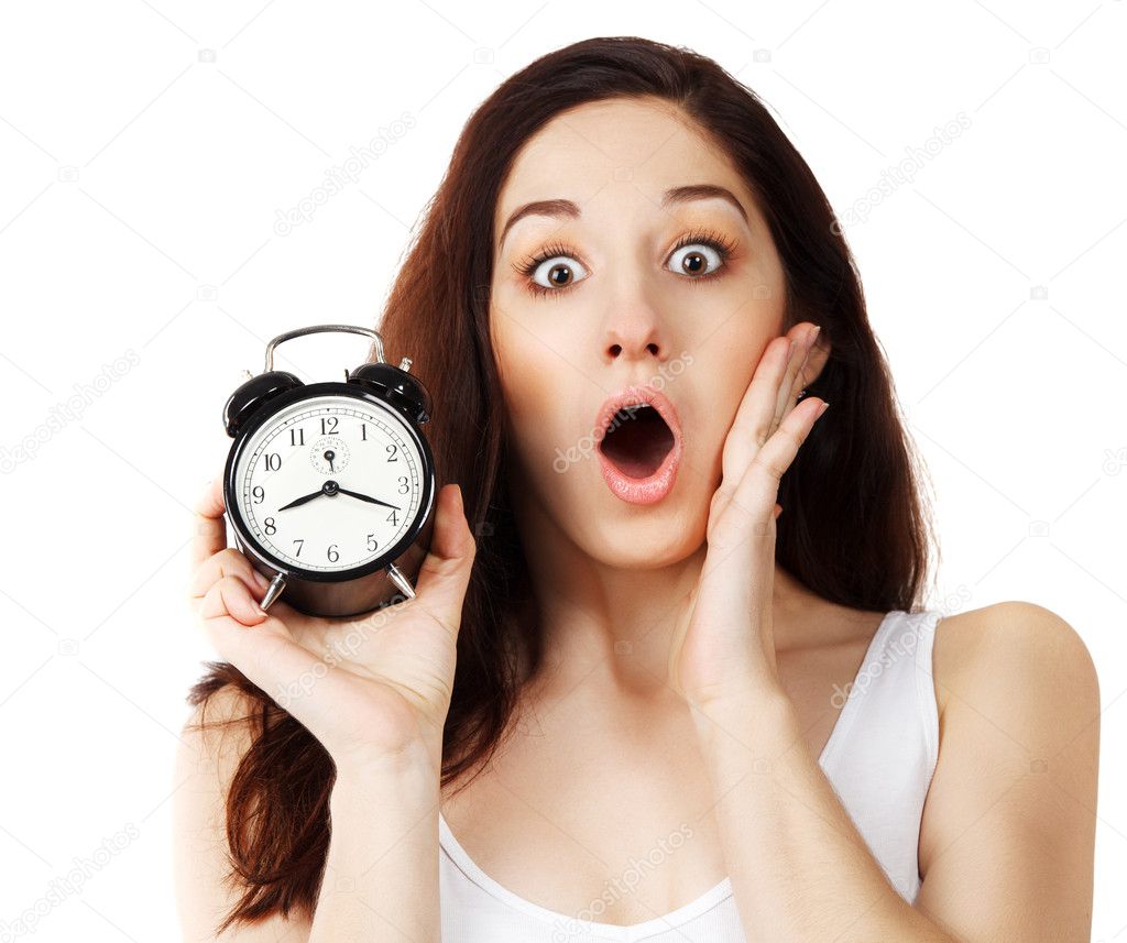 Surprised young brunette woman holding clock
