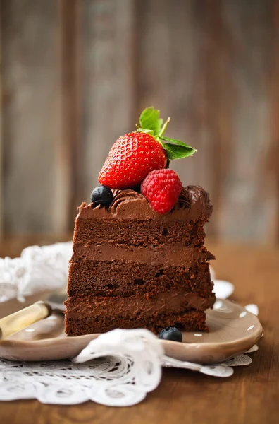 Pedaço de bolo de chocolate com cereja e bagas frescas — Fotografia de Stock