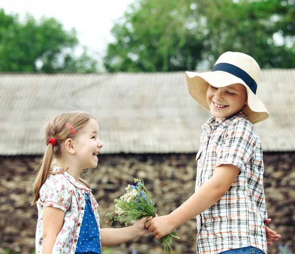 Little boy gives flowers to the little girl — Stock Photo, Image