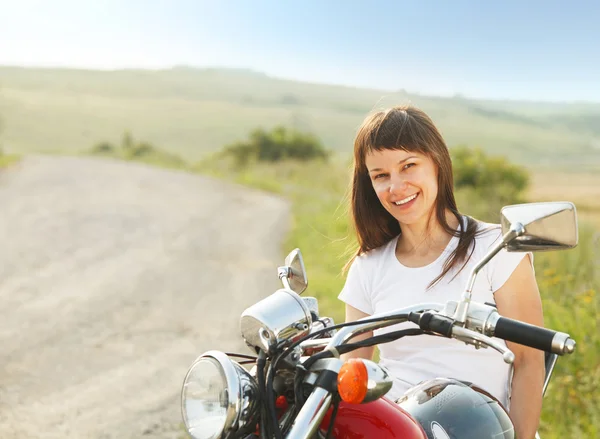 Jovem motociclista mulher na estrada do campo — Fotografia de Stock