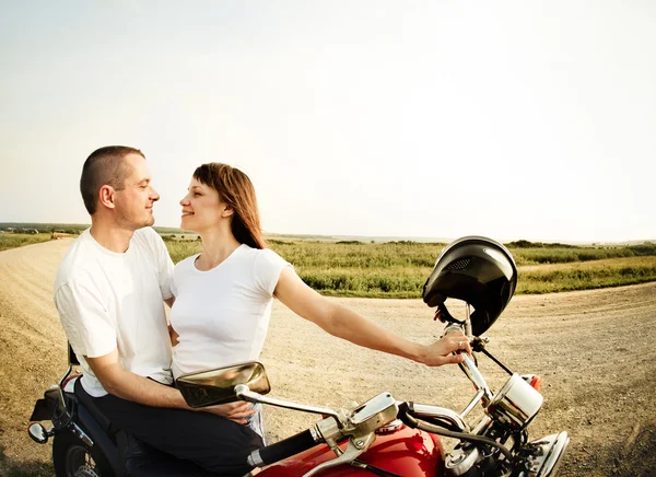 Mladý motorkář pár na polní cestě — Stock fotografie