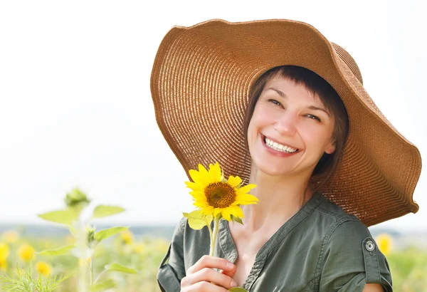 Portret van een jonge lachende vrouw met zonnebloemen — Stockfoto