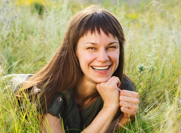 微笑在草甸上深色头发的女人 — 图库照片