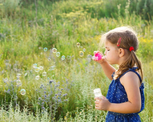 Little cute girl blowing soap bubbles — Stock Photo, Image