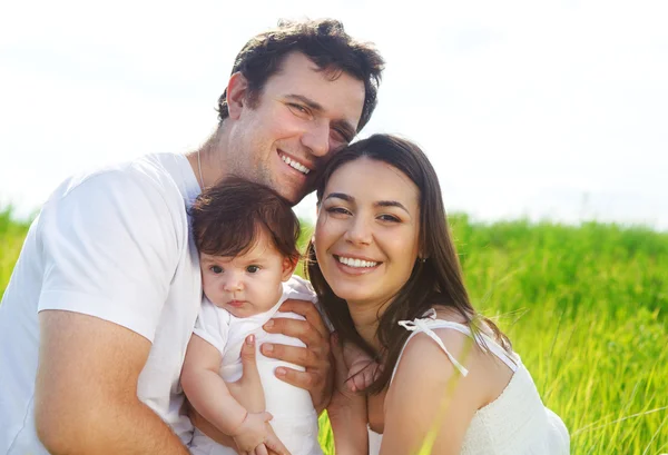 Jovem família feliz com a pequena menina — Fotografia de Stock