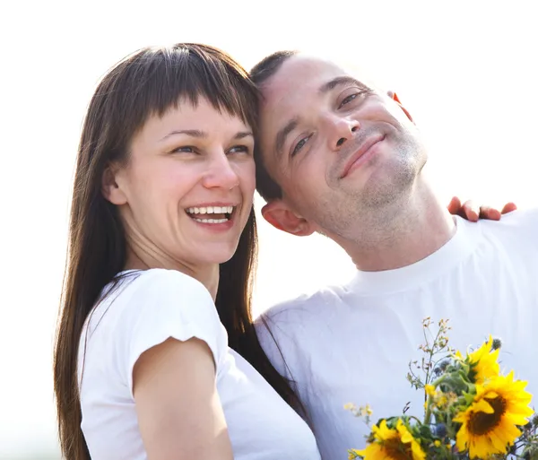 Feliz jovem casal com flores — Fotografia de Stock