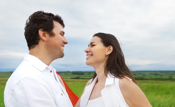 Jonge gelukkige paar in liefde met rode stof in zomerdag — Stockfoto