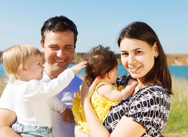 Щаслива молода сім'я з двома дітьми на відкритому повітрі — стокове фото