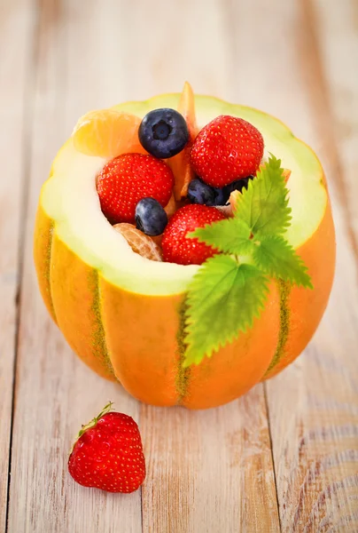 Deliciosos frutos frescos servidos em melão — Fotografia de Stock