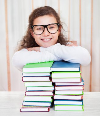 yığın kitap ile gözlüklü küçük kız