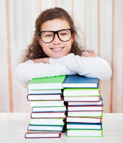 Little girl wearing glasses with pile of books — Stock Photo, Image