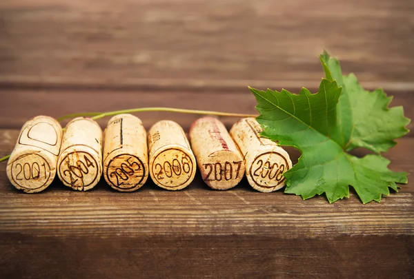 Gedateerd wijnfles kurken op de houten achtergrond — Stockfoto