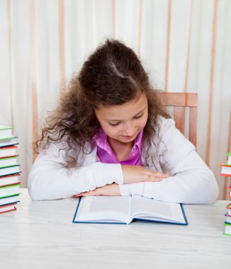 kitap yığınları ile küçük kız