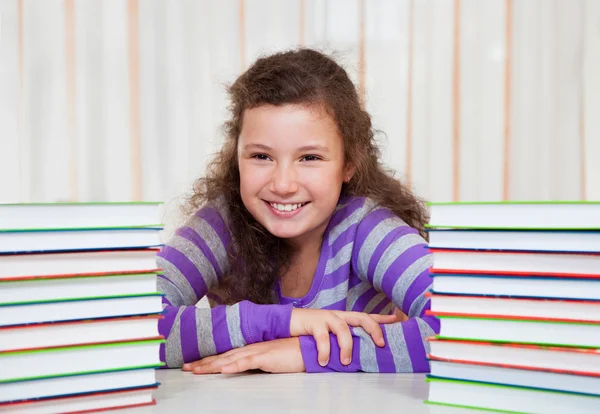 Kleines Mädchen mit Stapeln von Büchern — Stockfoto