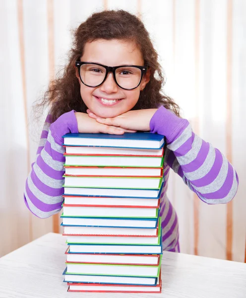 Kleines Mädchen mit Bücherstapel — Stockfoto