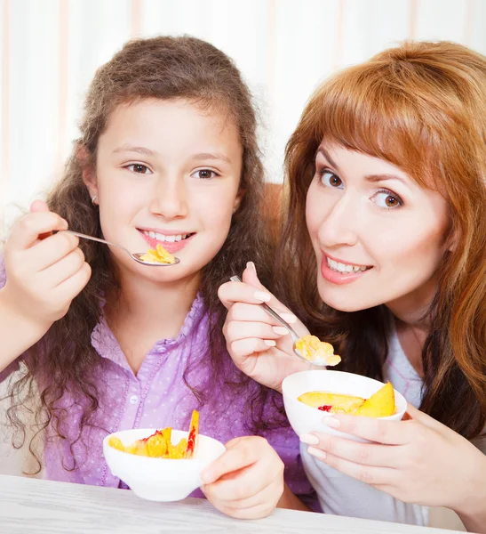 母亲和女儿吃谷类和水果 — 图库照片