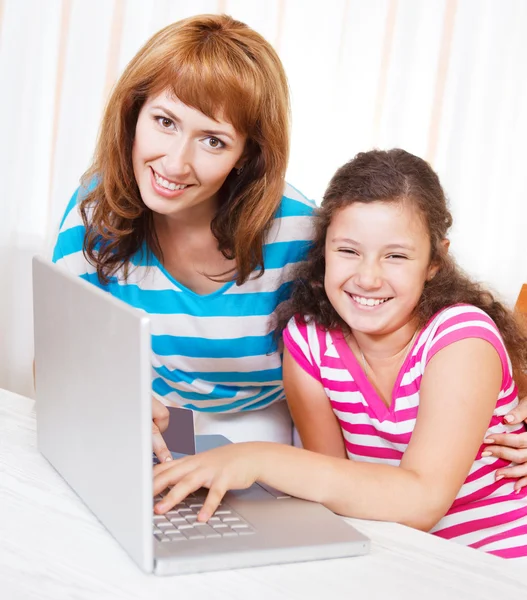 Mujer joven con hija usando computadora portátil —  Fotos de Stock