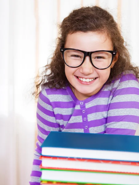 Kleine brünette lächelndes Mädchen mit Büchern — Stockfoto