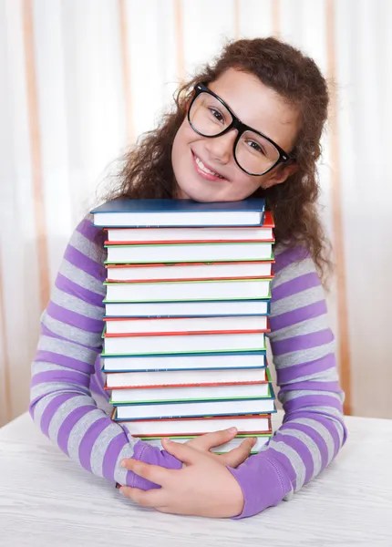 Kleine brünette lächelndes Mädchen mit Büchern — Stockfoto