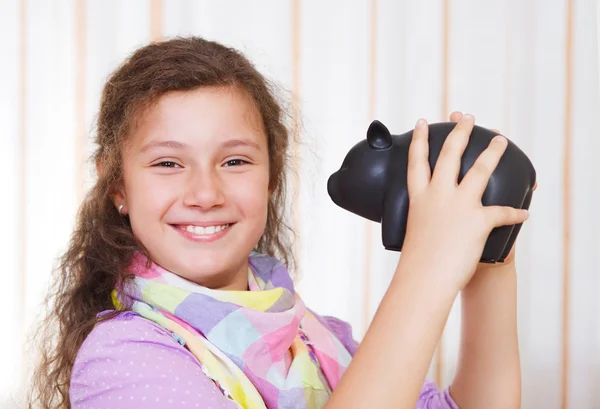 Kleines Mädchen spart Geld in Sparschwein — Stockfoto