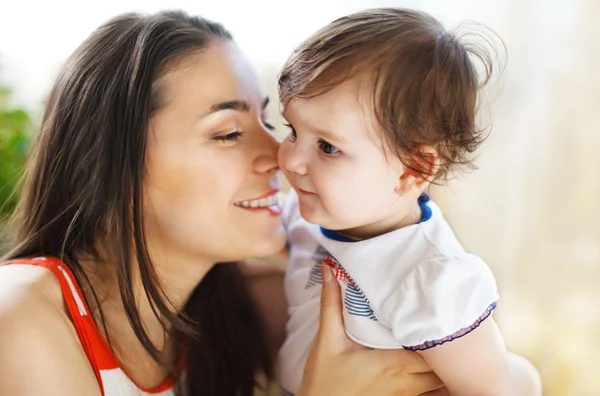 Glada leende mamma med baby flicka inomhus — Stockfoto