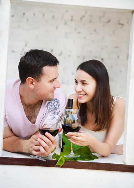 Jonge gelukkige paar genieten van een glazen rode wijn — Stockfoto