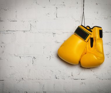 Pair of boxing gloves hanging on a wall clipart