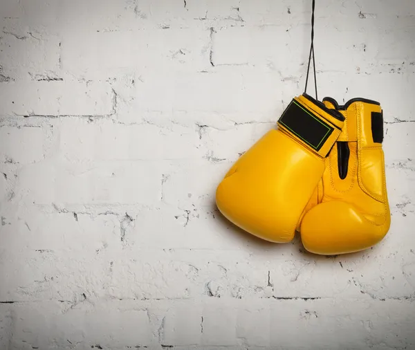 Par de guantes de boxeo colgados en una pared —  Fotos de Stock