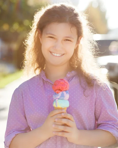 Smilling girl holding ice cream cone in her hands outdoors — Stock Photo, Image