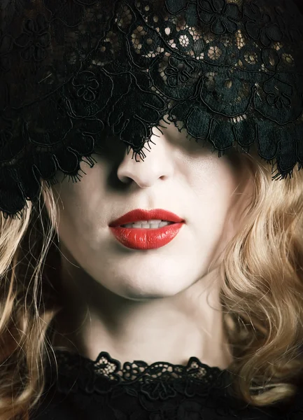 Красивая женщина с красными губами и кружевной маской — стоковое фото