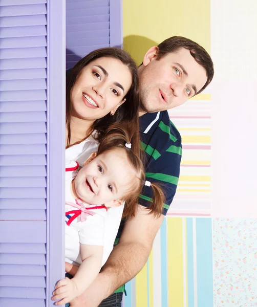 Feliz familia sonriente con una niña de un año —  Fotos de Stock