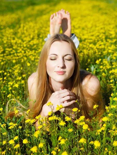年轻漂亮的金发女孩躺上雏菊花场 — 图库照片
