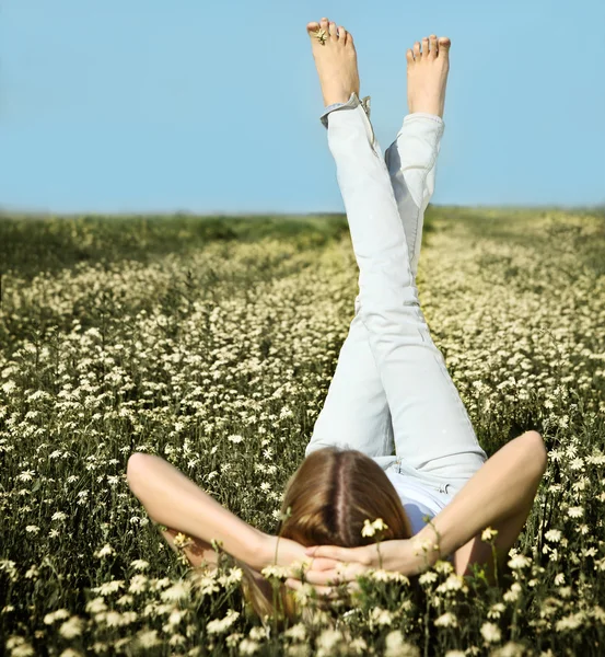 Jovem bela menina loira deitado no campo de flores margarida — Fotografia de Stock