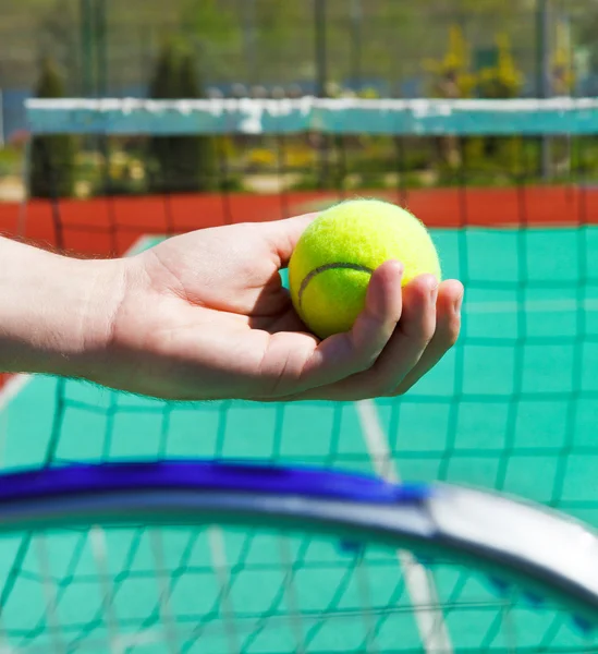 Close up of tennis racquet and ball in hands