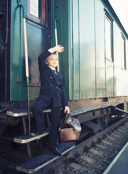 Bambino con una valigia nel treno retrò — Foto Stock