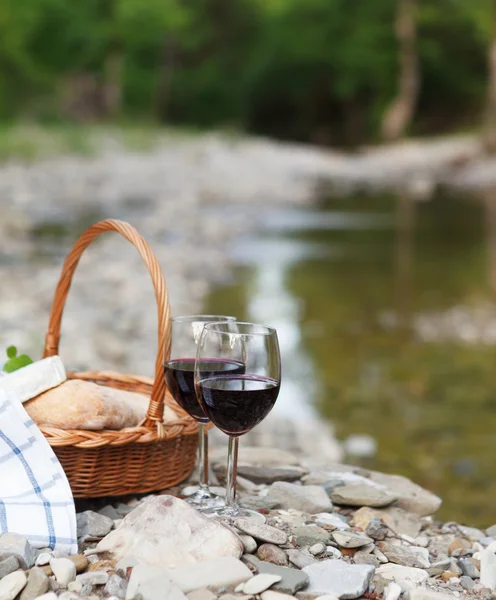 Червоне вино, сир і хліб подаються на пікнік — стокове фото