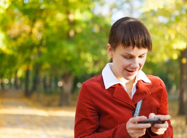 Portret uśmiechający się tekstylny piękna kobieta z jej telefon — Zdjęcie stockowe