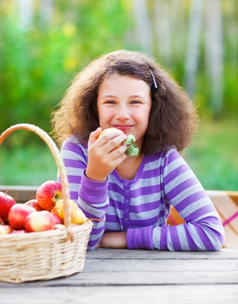 Ragazzina sorridente con cesto di mele rosse — Foto Stock