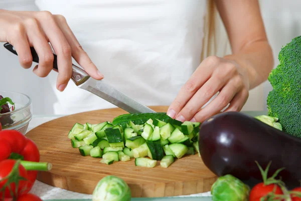 Mãos de uma mulher cortando legumes — Fotografia de Stock