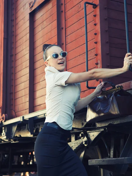 Vrouw met een koffer staande op het platform — Stockfoto