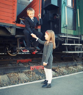 küçük çocuk ve trenin yanında küçük bir kız