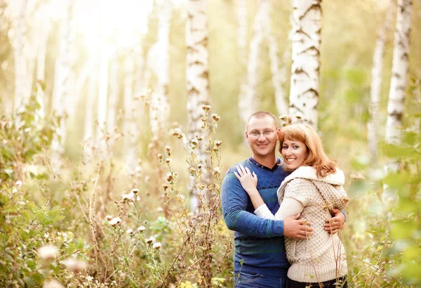 Szczęśliwy uśmiechający się para w lesie jesienią — Zdjęcie stockowe