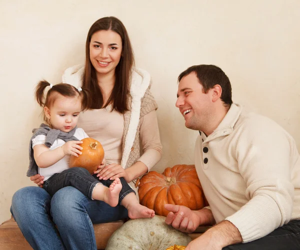 Счастливая улыбающаяся семья с осенними тыквами — стоковое фото