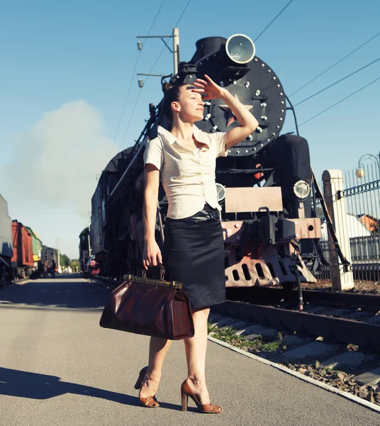 レトロな電車に近いプラットフォーム上のスーツケースを持つ女性 — ストック写真