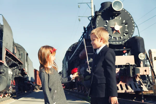 Kleiner Junge und kleines Mädchen in der Nähe der Züge — Stockfoto